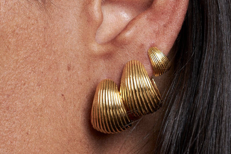 Close-up of golden earrings representing minimalist women's jewelry for everyday style.