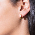 model wearing heptagon huggies 18k