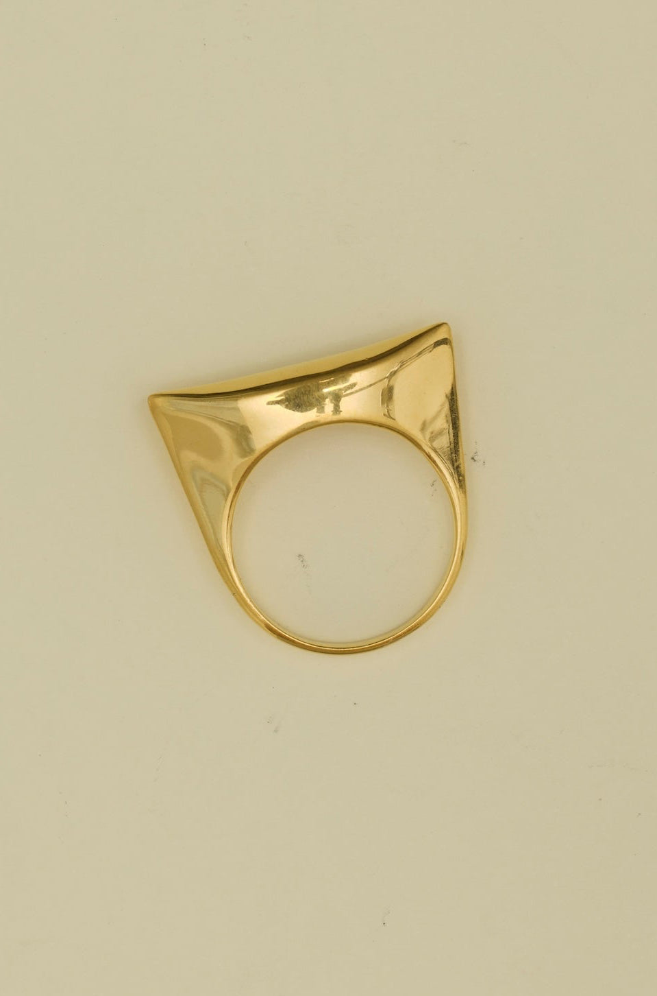 Gold cat-eye ring on a beige background