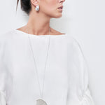 model wearing mesh necklace and sia earrings in silver