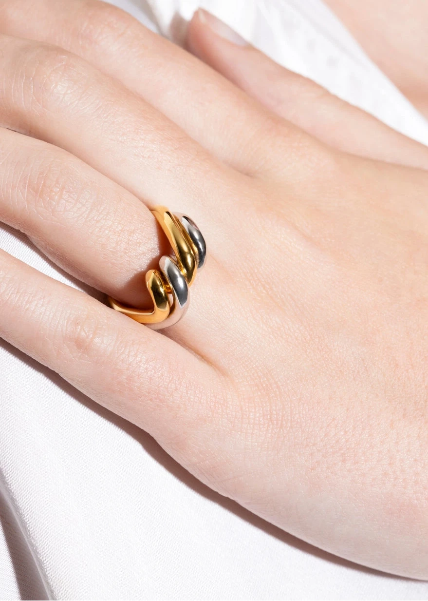 Gold ring on a person's finger with a white background