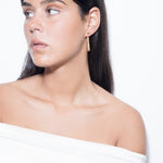 model wearing mini sade earrings in gold