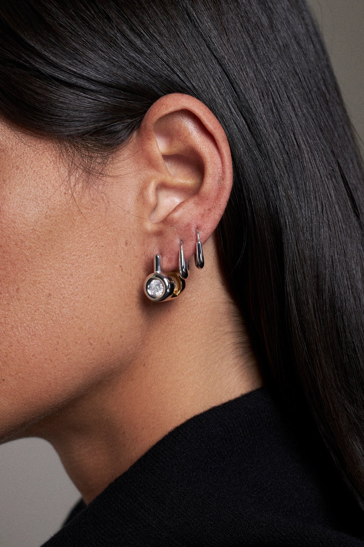 CINCO earrings with a unique design, showcased on a model's ear for a stylish view.